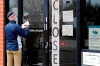 FILE - In this April 30, 2020 file photo, a man writes information in front of Illinois Department of Employment Security in Chicago. U.S. businesses cut an unprecedented 20.2 million jobs in April, an epic collapse with coronavirus outbreak closing the offices, factories, schools, construction sites and stores that propel the U.S. economy. The Wednesday, May 6, report from payroll company ADP showed the tragic depth and scale of job losses that left no part of the world’s largest economy unscathed.  (AP Photo/Nam Y. Huh, File)