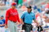 FILE - In this March 8, 2020, file photo, Philadelphia Phillies' pitching coach Bryan Price walks with umpire Phil Cuzzi during a spring training baseball game, Sunday,, in Dunedin, Fla. Price could end up being the most valuable addition the Phillies made in the offseason if he can get some talented members of the staff to reach their potential.(AP Photo/Carlos Osorio, File)