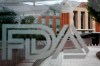 FILE - This Aug. 2, 2018, file photo shows the U.S. Food and Drug Administration building behind FDA logos at a bus stop on the agency's campus in Silver Spring, Md. U.S. regulators warned several companies to stop selling soaps, sprays and other concoctions with false claims that they can treat the new coronavirus or keep people from catching it. The warnings were emailed Friday, March 6, 2020, to companies based in the U.S., Canada and the U.K. and were announced Monday. Nearly all the targeted companies had complied by Monday morning, with mentions of the virus or products to treat it taken off their websites. (AP Photo/Jacquelyn Martin, File)