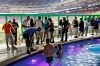 FILE - In this April 2, 2012 file photo fans watch from the swimming pool at Marlins Park during a spring training baseball game between the Miami Marlins and the New York Yankees in Miami. The Clevelander nightclub at Marlins Park has closed. It included a swimming pool, dancers and DJs, and had been a staple at the ballpark since it opened in 2012. The space will still be accessible to fans with different seating and without the pool, but the bar remains. Marlins Park has undergone a gradual makeover since Derek Jeter's group bought the team in late 2017. Before the 2019 season, Jeter removed the kitschy home run sculpture from the outfield. (AP Photo/Wilfredo Lee, file)