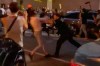 In this May 29, 2020 photo taken from video New York police officer Vincent D'Andraia, right, pushes protester Dounya Zayer during a protest in the Brooklyn borough of New York. D'Andraia is facing criminal charges after he was caught on video violently shoving Zayer to the ground during the protest over the death of George Floyd. Brooklyn prosecutors charged Officer Vincent D'Andraia on Tuesday with assault and other counts in the May 29 confrontation. (Whitney Hu via AP)