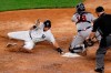 New York Yankees DJ LeMahieu, left, scores on Aaron Hick's fourth-inning double as Atlanta Braves catcher Travis d'Arnaud, center, waits for the throw in a baseball game, Wednesday, Aug. 12, 2020, in New York. Home plate umpire Todd Tichenor watches the play at right. (AP Photo/Kathy Willens)
