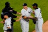 Officials and New York Yankees' DJ LeMahieu restrain New York Yankees relief pitcher Aroldis Chapman, right, after he and the Tampa Bay Rays exchanged words at the end of a baseball game, Tuesday, Sept. 1, 2020, at Yankee Stadium in New York. The incident occurred after Chapman threw a high pitch at the Rays' Michael Brosseau in the ninth inning. (AP Photo/Kathy Willens)