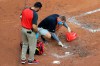 Members of the Reds' crew clean blood out of the dirt from MLB umpire Chris Conroy (98) in the first inning during a baseball game between the Kansas City Royals and the Cincinnati Reds in Cincinnati, Wednesday, Aug. 12, 2020. (AP Photo/Aaron Doster)