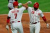 Cincinnati Reds' Eugenio Suarez, left, congratulates Joey Votto, who hit a solo home run during the third inning of the team's baseball game against the Chicago White Sox in Cincinnati, Friday, Sept. 18, 2020. (AP Photo/Aaron Doster)