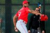 FILE - In this Feb. 17, 2020, file photo, Cincinnati Reds relief pitcher Amir Garrett (50) delivers during a bullpen session at the baseball team's spring training facility in Goodyear, Ariz. As one of only two Black players on the Cincinnati Reds, reliever Amir Garrett was afraid to use his platform to speak about racial injustice. That's changed, and he's brought teammates along in pressing for change. (Kareem Elgazzar/The Cincinnati Enquirer via AP, File)