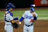 Los Angeles Dodgers manager Dave Roberts (30) tosses a ball out of play as he comes to the mound to change pitchers against the Arizona Diamondbacks as Dodgers catcher Austin Barnes, left, looks on during the sixth inning of a baseball game Friday, July 31, 2020, in Phoenix. (AP Photo/Ross D. Franklin)