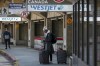 A passsenger waits at the WestJet end of the Calgary airport after the company laid off nearly 7000 employees, in Calgary, Alta., Wednesday, March 25, 2020. WestJet Airlines Ltd. is extending its suspension of thousands of flights by another four weeks until July 4 due to the COVID-19 pandemic. THE CANADIAN PRESS/Jeff McIntosh