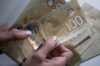 Canadian $100 bills are counted in Toronto, Feb. 2, 2016. The Conference Board of Canada says the economy may have already begun to recover from the deepest recession on record if the country can avoid another national COVID-related shutdown. THE CANADIAN PRESS/Graeme Roy