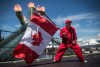 Ricky Johnson waves a Canadian flag on a hockey stick as the Olympic cauldron burns while attending Canada Day celebrations in Vancouver, on Monday July 1, 2019. A different kind of Canada Day is dawning this morning, with large celebrations in many parts of the country replaced with backyard barbecues and digital events. THE CANADIAN PRESS/Darryl Dyck