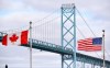 Canadian and American flags fly near the Ambassador Bridge at the Canada/USA border crossing in Windsor, Ont. on Saturday, March 21, 2020. THE CANADIAN PRESS/Rob Gurdebeke