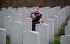 Alisha Lawrence hugs her son Declan Edwards, 3, as they pay their respects at the grave of her grandfather Frank Davies, who served in the army and air force, after a Remembrance Day ceremony at the National Military Cemetery in Ottawa, on Wednesday, Nov. 11, 2020. THE CANADIAN PRESS/Justin Tang