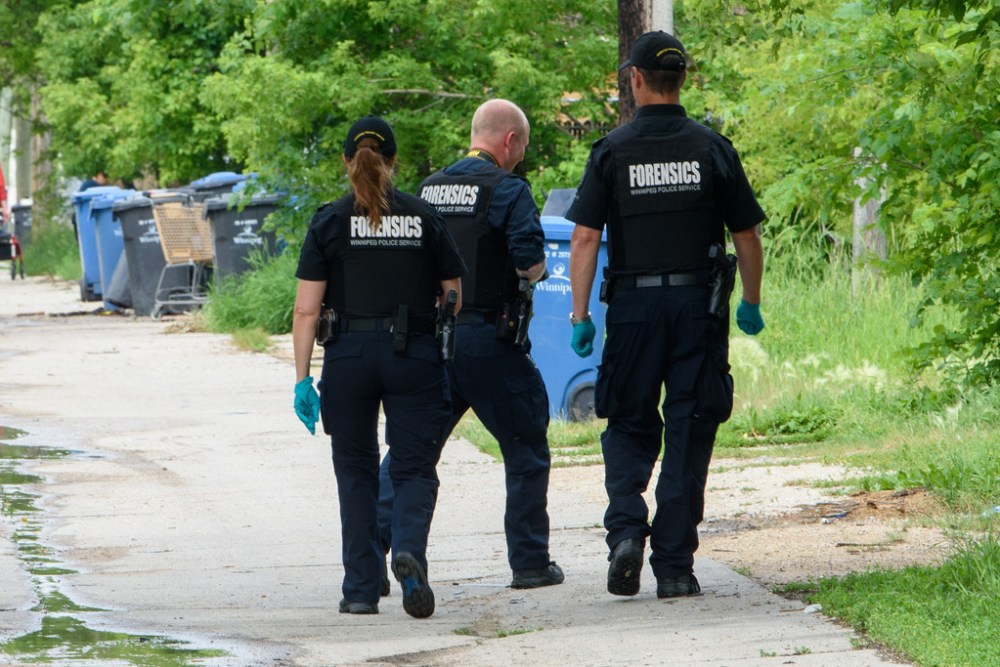 Police investigate the scene of a double shooting near Salter Street and Flora Avenue on Wednesday. Danielle Dawn Cote, 27, died from her injuries. (Jesse Boily / Winnipeg Free Press)