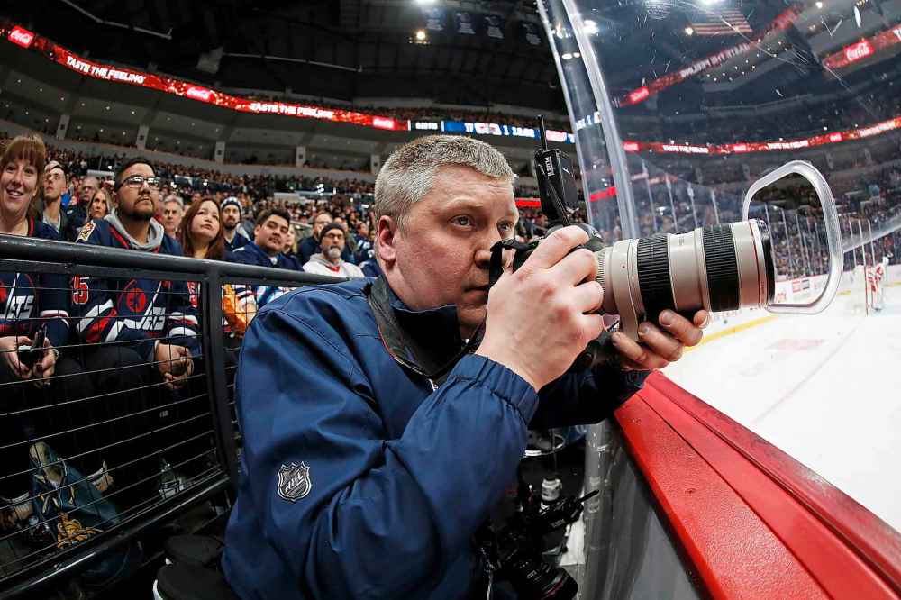 JOHN WOODS / WINNIPEG FREE PRESS
Winnipeg Jets’ head photographer Jonathan Kozub takes photos for the Jets during a recent game.