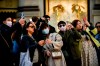 People, some wearing sanitary masks, take photos in central Milan, Italy, Monday, Feb. 24, 2020. At least 190 people in Italy’s north have tested positive for the COVID-19 virus and four people have died, including an 84-year-old man who died overnight in Bergamo, the Lombardy regional government reported. (Claudio Furlan/Lapresse via AP)