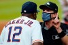 Umpire Chris Guccione, right, talks to Houston Astros manager Dusty Baker (12) after both benches emptied onto the field after the sixth inning of a baseball game against the Los Angeles Dodgers Tuesday, July 28, 2020, in Houston. (AP Photo/David J. Phillip)