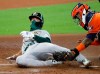 Oakland Athletics' Mark Canha, left, is tagged out at the plate by Houston Astros catcher Martin Maldonado while trying to score on a double by Ramon Laureano in the second inning during the first baseball game of a doubleheader on Saturday, Aug. 29, 2020, in Houston. (Kevin M. Cox/The Galveston County Daily News via AP)