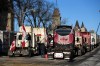 A person walks among trucks as Wellington Street is lined with trucks once again after city officials negotiated to move some trucks towards Parliament and away from downtown residences. (Justin Tang / The Canadian Press)