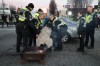 Police officers remove an elderly woman from the road where protesters demonstrating in solidarity with Wet'suwet'en hereditary chiefs opposed to construction of the Coastal GasLink natural gas pipeline across their traditional territories were blocking an entrance to the port, in Vancouver, on Monday February 10, 2020. THE CANADIAN PRESS/Darryl Dyck