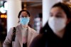 Travelers at Seattle-Tacoma International Airport wear masks Tuesday, March 3, 2020, in SeaTac, Wash. Six of the 18 Western Washington residents with the coronavirus have died as health officials rush to test more suspected cases and communities brace for spread of the disease. All confirmed cases of the virus in Washington are in Snohomish and King counties. (AP Photo/Elaine Thompson)