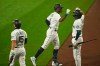 Seattle Mariners' Kyle Lewis, center, is greeted by Evan White, right, as Kyle Seager (15) looks on after Lewis hit a two-run home run against the Oakland Athletics during the fifth inning of the first baseball game of a doubleheader, Monday, Sept. 14, 2020, in Seattle. (AP Photo/Ted S. Warren)