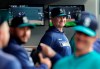 FILE - In this April 12, 2019 file photo, Seattle Mariners manager Scott Servais, center, smiles in the dugout before a baseball game against the Houston Astros in Seattle. Spring training for the Mariners ahead of the 2020 season will feature young players and prospects that could be at the heart of whether the Mariners' rebuild plans ultimately work. (AP Photo/Ted S. Warren, File)