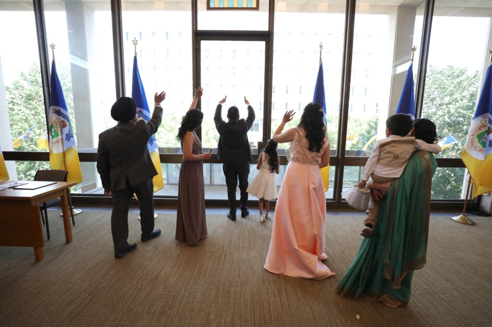 RUTH BONNEVILLE / WINNIPEG FREE PRESS
The couple and their family wave to friends that had to remain outside the building due to COVID restrictions of 15 people. The young couple are the first to have their wedding at City Hall since it was closed during the pandemic.