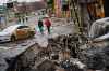 Residents carrying supplies walk back from the direction of Bucha, amid the debris of battle with Russian forces, on the outskirts of Irpin, Ukraine, Tuesday, March 1, 2022. (Marcus Yam/Los Angeles Times/TNS)