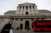 FILE - In this file photo dated Wednesday, March 11, 2020, pedestrians wearing face masks walk past the Bank of England in London. The Bank of England kept its main interest rate unchanged at the record low of 0.1% on Thursday Sept. 17, 2020, as it waits to see how the economy recovers from recession and what Britain’s future trade relationship with the European Union will be. (AP Photo/Matt Dunham, FILE)