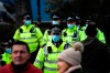 Police officers wear face masks as they patrol an anti-lockdown demonstration in Parliament Square, in London, Monday, Dec. 14, 2020. Britain launched its vaccination program this month after becoming the first country to give emergency approval to the Pfizer-BioNtech vaccine, and authorities plan to dispense 800,000 doses in the first phase. (AP Photo/Alberto Pezzali)