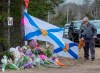 A man pays his respects at a roadside memorial in Portapique, N.S. on Thursday, April 23, 2020. RCMP say at least 22 people are dead after a man who at one point wore a police uniform and drove a mock-up cruiser, went on a murder rampage in Portapique and several other Nova Scotia communities. THE CANADIAN PRESS/Andrew Vaughan