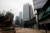 A woman wearing a protective face mask walks alone at a quiet office buildings compound in Beijing, Monday, Feb. 24, 2020. Regulators on Monday promised tax cuts and other aid to help companies recover from China's virus outbreak and expressed confidence the ruling Communist Party's growth targets can be achieved despite anti-disease controls that shut down much of the economy. (AP Photo/Andy Wong)