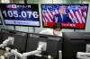 An employee works near a TV monitor showing a live broadcasting of the press conference by President Donald Trump, at a foreign exchange dealing company Wednesday, Nov. 4, 2020, in Tokyo. (AP Photo/Eugene Hoshiko)