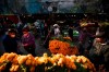 Customers, wearing protective face masks amid the new cornavirus pandemic, shop for flowers at the Jamaica Market, in Mexico City, Thursday, Oct. 29, 2020. Mexico’s Day of the Dead celebration this weekend won’t be the same in a year so marked by death, in a country where more than 90,000 people have died of COVID-19. Many of those had to be cremated rather than buried, and even for those with gravesides to visit, the pandemic has forced authorities in most parts of Mexico to close cemeteries to prevent the traditional Nov. 1-2 observances when entire families clean and decorate tombs. (AP Photo/Fernando Llano)