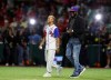 Retired Boston Red Sox player David Ortiz of the Dominican Republic, affectionately known as Big Papi, right, and Puerto Rican singer Ozuna, walk onto the field for the opening pitch of the Caribbean Series baseball game between Dominican Republic and Puerto Rico, in San Juan, Puerto Rico, Wednesday, Feb. 5, 2020.(AP Photo/Fernando Llano)