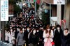 FILE - In this Feb. 20, 2020, file photo, people wear masks as they commute during the morning rush hour in Chuo district in Tokyo. China's massive travel restrictions, house-to-house checks, huge isolation wards and lockdowns of entire cities bought the world valuable time to prepare for the global spread of the new virus. (AP Photo/Kiichiro Sato, File)