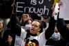 A woman holds a sign as protesters gather in Sydney, Tuesday, June 2, 2020, to support the cause of U.S. protests over the death of George Floyd and urged their own governments to address racism and police violence. Floyd died last week after he was pinned to the pavement by a white police officer who put his knee on the handcuffed black man's neck until he stopped breathing. (AP Photo/Rick Rycroft)