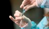 A medical worker holding a Pfizer-BioNTech vaccine and a syringe during mass vaccination starts in Vienna, Austria, Friday, Jan. 15, 2021. Authorities started to vaccinate the most vulnerable people in a coordinated effort. (AP Photo/Ronald Zak)