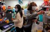 People wear protective face masks as they make purchases from a convenience store in Hong Kong, Monday, Feb, 3, 2020. Lam says the city will shut almost all land and sea border control points to the mainland from midnight to stem the spread of the novel coronavirus from China. (AP Photo/Vincent Yu)