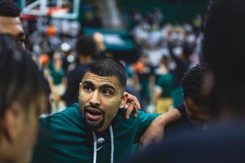 - Cara Kaye/Creative Director at Michigan State University
Manny Dosanjh photographed in a Michigan State huddle. He is making history as the first Canadian of Indian descent to hold an assistant coach job at the NCAA.