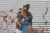 ALLISON DINNER - AFP via GETTY IMAGES
A woman cries and hugs a young girl while on the phone outside the Willie de Leon Civic Center where grief counseling will be offered in Uvalde, Texas, on May 24, 2022.