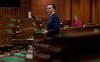 With a limited number of Members of Parliament on hand and spread out, Minister of Finance Bill Morneau responds to a question after tabling the governments COVID19 financial measures bill in the House of Commons Wednesday March 25, 2020 in Ottawa. THE CANADIAN PRESS/Adrian Wyld