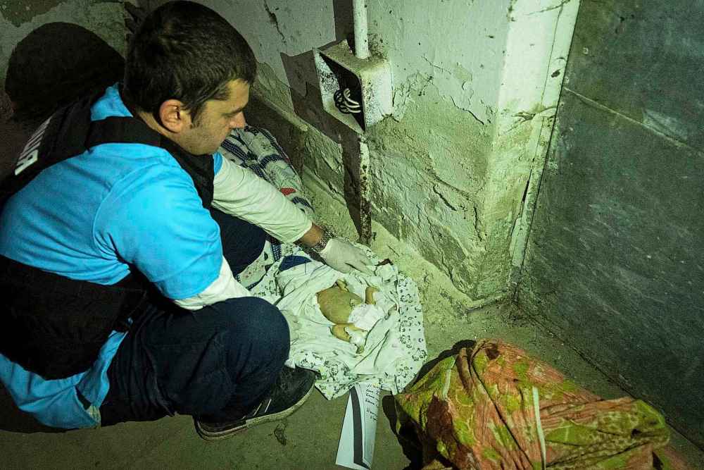 A doctor shows bodies of children killed by shelling at No. 3 hospital in Mariupol, Ukraine, Tuesday, March 15, 2022. (Mstyslav Chernov / The Associated Press)