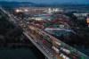 In this Tuesday, Jan. 28, 2020, photo, construction trucks are lined up at the site of the Huoshenshan temporary field hospital being built in Wuhan in central China's Hubei Province. China as of Wednesday has more infections of a new virus than it did in with SARS, though the death toll is still lower. (Chinatopix via AP)