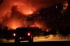 DARRYL DYCK - THE CANADIAN PRESS
A motorist watches from a pullout on the Trans-Canada Highway as a wildfire burns on the side of a mountain in Lytton, B.C., on July 1, 2021.