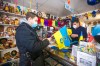 Svitoch Ukrainian Export & Import owner Ruslan Zeleniuk (right) packs up flags for Alexey, who has family in the Luhansk region. (Mikaela MacKenzie / Winnipeg Free Press)