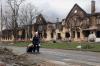 Alexei Alexandrov - The Associated Press
A woman pulls her bags past houses damaged during fighting in eastern Mariupol, Ukraine last Friday. Ukraine says it is investigating a claim that a poisonous substance was dropped on the besieged city of Mariupol.