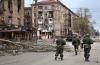 Alexei Alexandrov - AP
Servicemen of the militia from the Donetsk People's Republic walk past damaged apartment buildings in an area controlled by Russian-backed separatist forces in Mariupol, Ukraine.