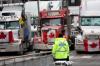 Scott Olson - GETTY IMAGES
A police officer stands guard near trucks participating in a blockade of downtown streets near the parliament building on Wednesday.