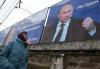 STRINGER - AFP via GETTY IMAGES
A woman walks past huge placards bearing images of Russian President Vladimir Putin in the city center of Simferopol, Crimea, on Friday. The one on left reads“Russia does not start wars, it ends them.” On right, “We will aim for the demilitarization and denazification of Ukraine.”